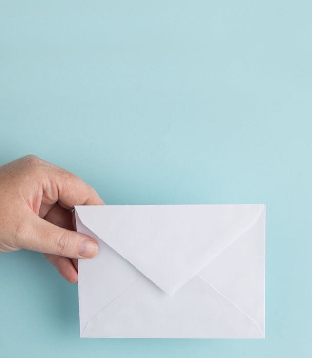 Eine Hand, die ein Kuvert hält