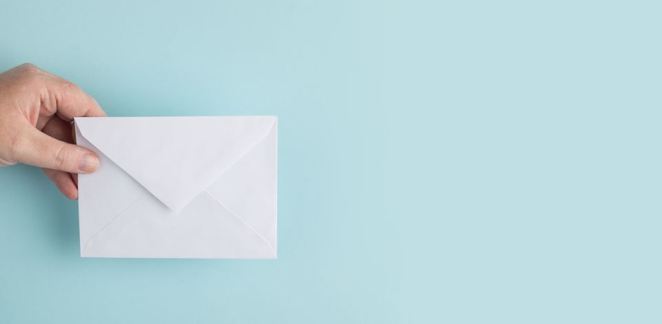 Eine Hand, die ein Kuvert hält